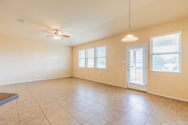 tiled spare room with ceiling fan