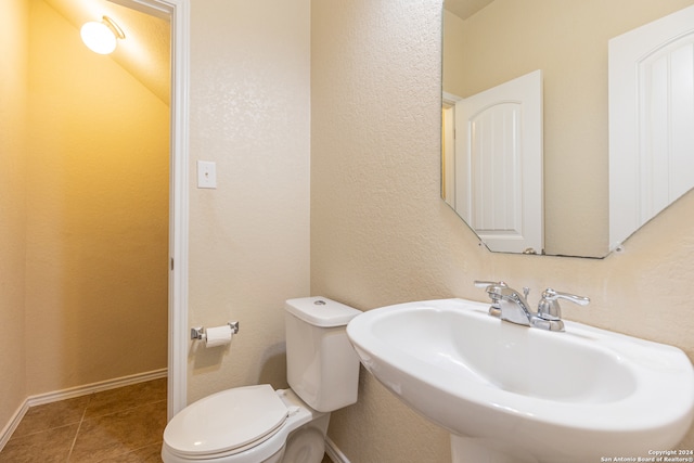 bathroom featuring toilet, sink, and tile patterned floors