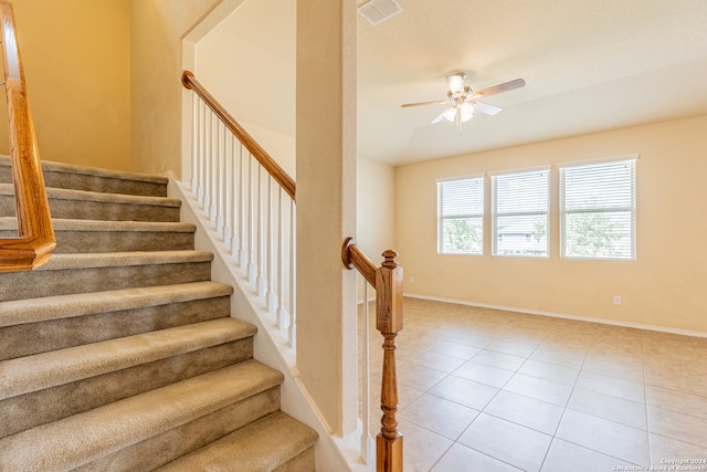 stairs with tile patterned flooring and ceiling fan