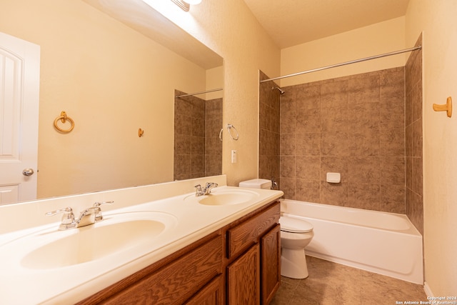 full bathroom with tile patterned floors, vanity, tiled shower / bath combo, and toilet