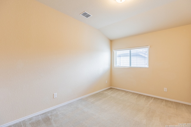 carpeted spare room featuring lofted ceiling