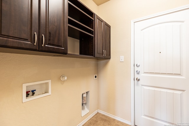 clothes washing area with gas dryer hookup, washer hookup, light tile patterned floors, cabinets, and electric dryer hookup