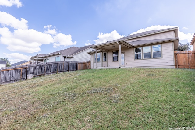 rear view of property featuring a yard