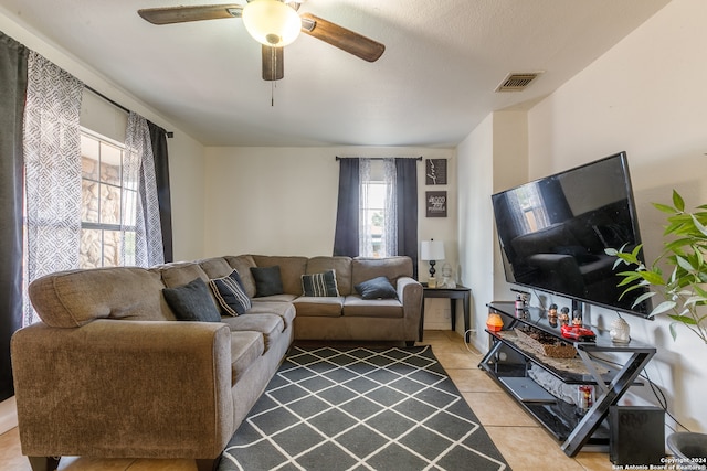 tiled living room featuring a textured ceiling, a healthy amount of sunlight, and ceiling fan