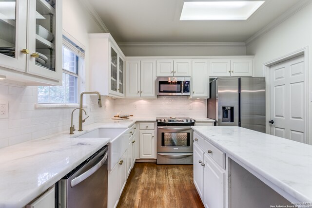 kitchen with dark hardwood / wood-style flooring, white cabinetry, appliances with stainless steel finishes, and light stone counters