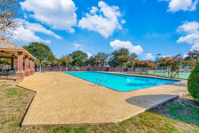 view of swimming pool featuring ceiling fan and a patio