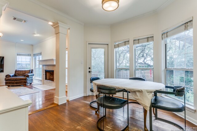 dining area with a wealth of natural light, dark hardwood / wood-style floors, and a tiled fireplace