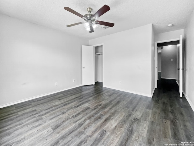 unfurnished bedroom with dark wood-type flooring, a textured ceiling, and ceiling fan