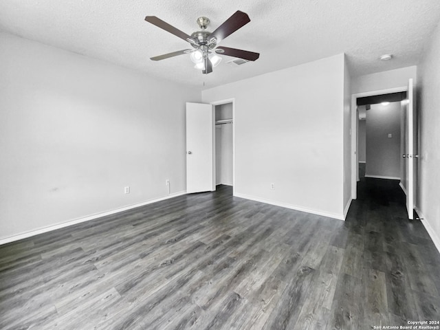 unfurnished bedroom featuring a textured ceiling, dark wood-style flooring, baseboards, a closet, and ceiling fan