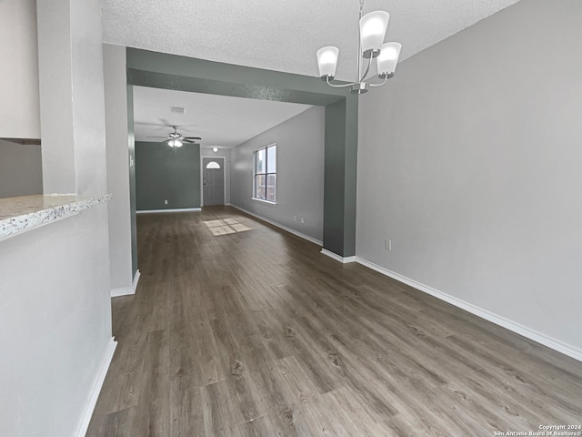 unfurnished living room featuring dark hardwood / wood-style floors, a textured ceiling, and ceiling fan with notable chandelier