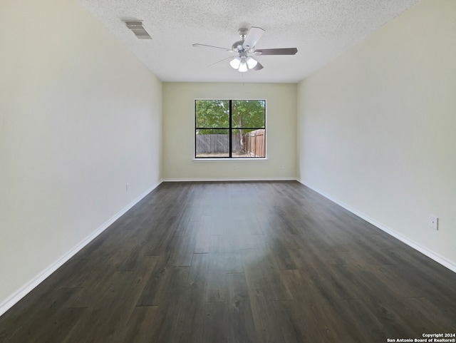 spare room featuring dark hardwood / wood-style flooring, a textured ceiling, and ceiling fan