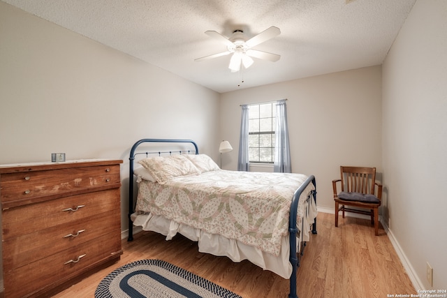 bedroom featuring a textured ceiling, light hardwood / wood-style floors, and ceiling fan