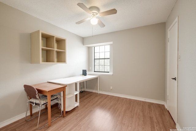 office area with light hardwood / wood-style floors, ceiling fan, and a textured ceiling