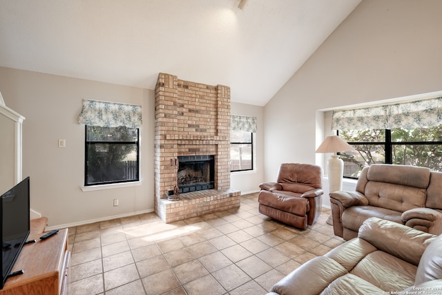 living room with a brick fireplace, a wealth of natural light, light tile patterned floors, and high vaulted ceiling