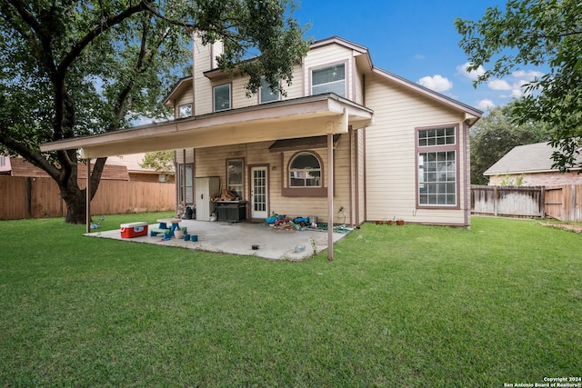 back of house featuring a patio area and a yard