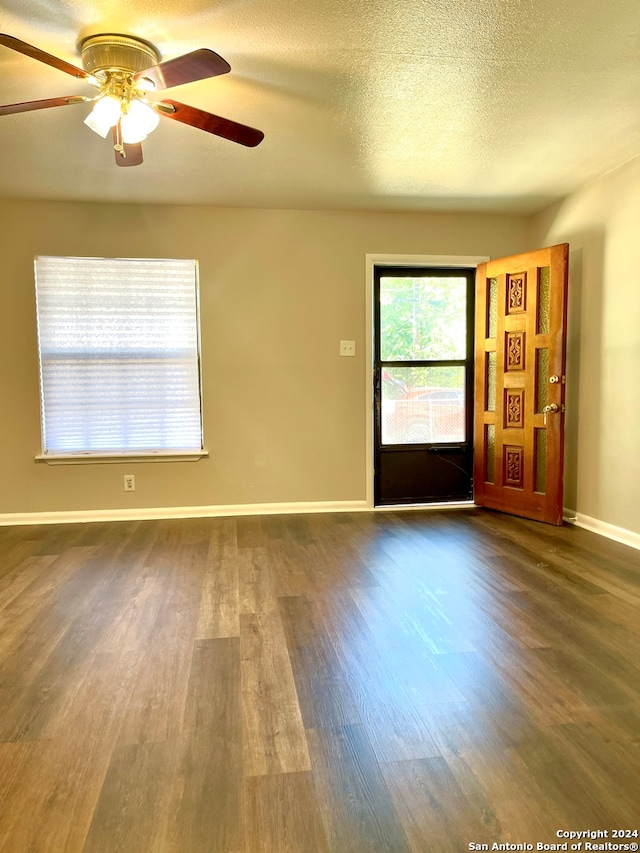 spare room with ceiling fan, dark hardwood / wood-style flooring, and a textured ceiling