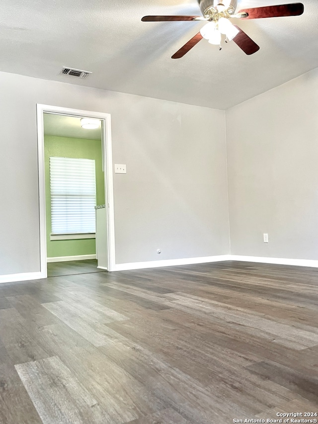 empty room featuring ceiling fan, dark hardwood / wood-style flooring, and a textured ceiling