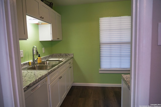 kitchen with light stone countertops, dark wood-type flooring, sink, dishwasher, and white cabinetry