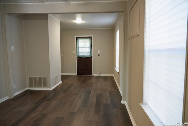 entryway with dark wood-type flooring and ornamental molding