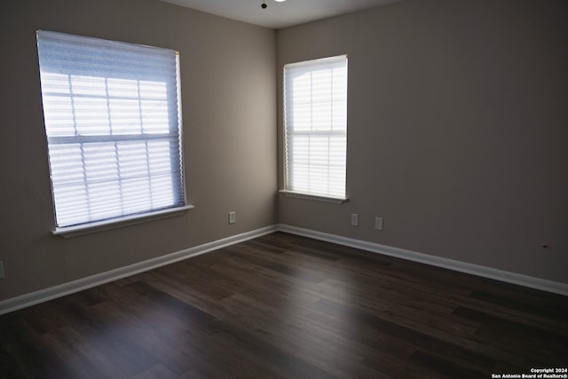 empty room with dark hardwood / wood-style flooring