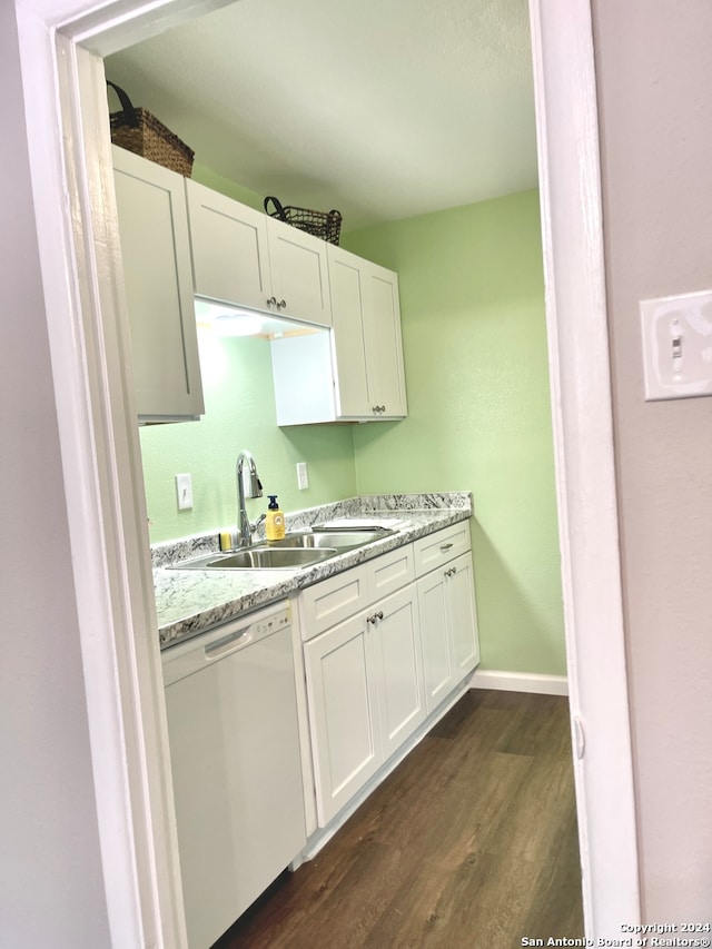 kitchen featuring light stone counters, white dishwasher, sink, dark hardwood / wood-style floors, and white cabinetry