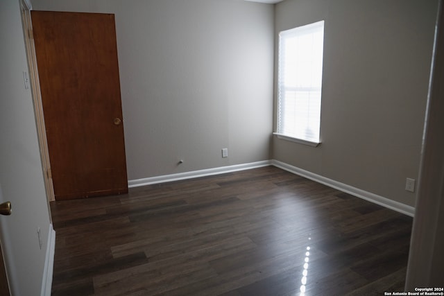 unfurnished room with dark hardwood / wood-style flooring