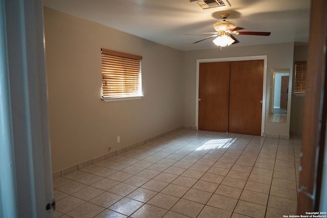 unfurnished bedroom with a closet, ceiling fan, and light tile patterned flooring