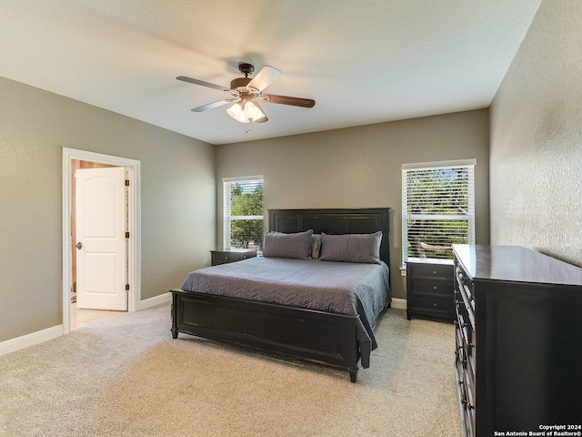 carpeted bedroom with multiple windows and ceiling fan