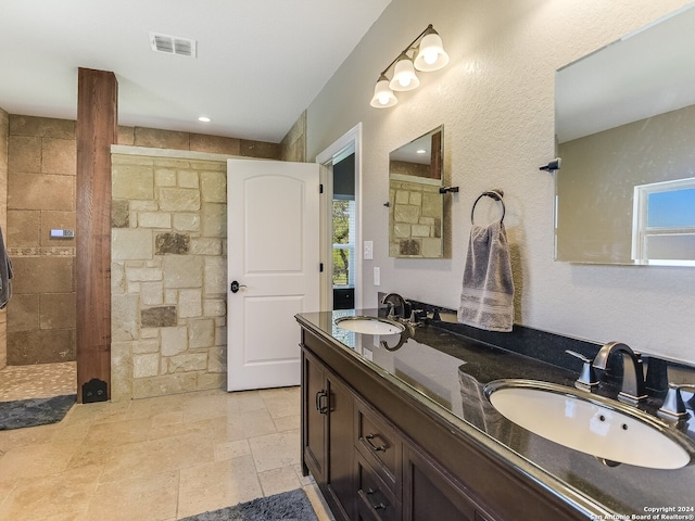 bathroom with vanity, tiled shower, and plenty of natural light