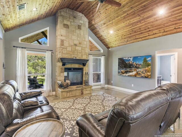 living room with wooden ceiling, ceiling fan, a stone fireplace, and high vaulted ceiling