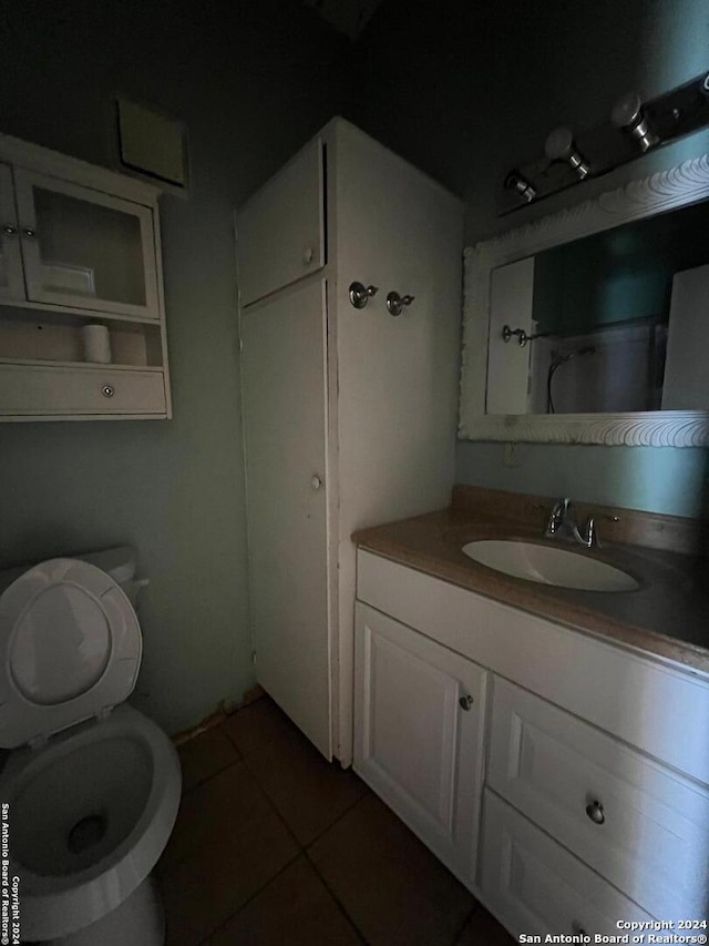 bathroom featuring vanity, tile patterned floors, and toilet