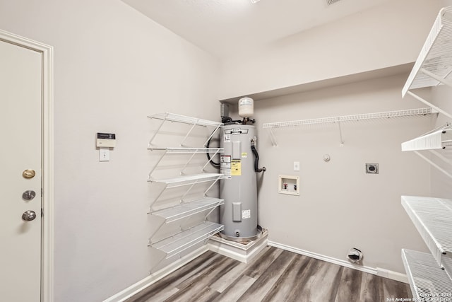 clothes washing area with hookup for an electric dryer, hardwood / wood-style floors, water heater, hookup for a washing machine, and hookup for a gas dryer