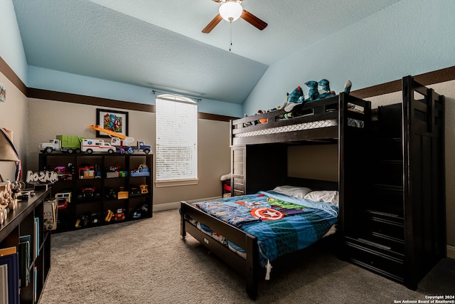 bedroom featuring lofted ceiling, a textured ceiling, carpet, and ceiling fan