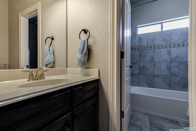 bathroom with tiled shower / bath combo and vanity