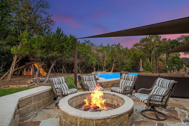 patio terrace at dusk featuring a fire pit