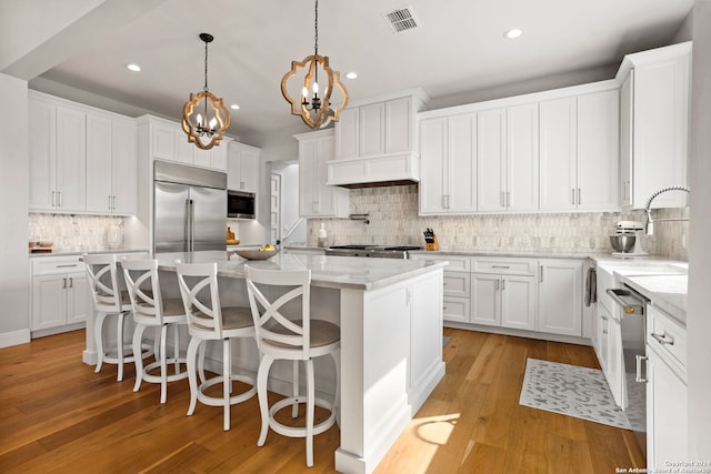 kitchen with white cabinetry, stainless steel appliances, and a kitchen island