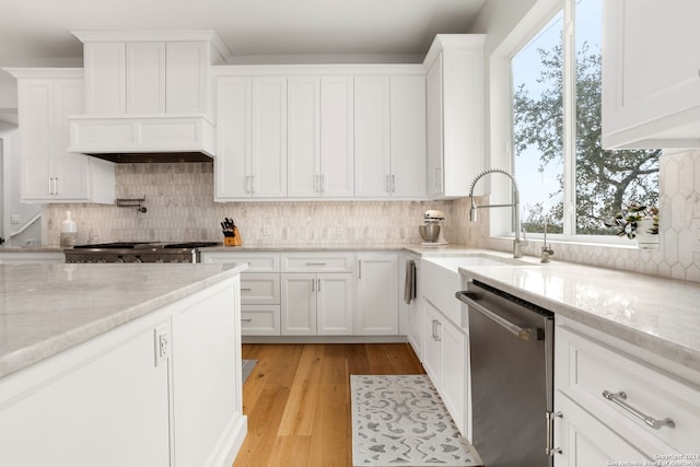 kitchen featuring stainless steel appliances, white cabinets, light wood-type flooring, and light stone counters