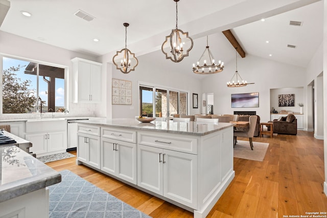 kitchen with white cabinets, light wood-type flooring, dishwasher, and decorative light fixtures