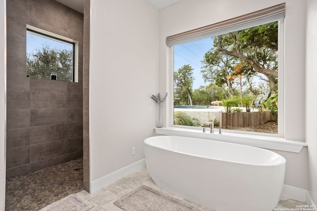 bathroom with a tub and plenty of natural light