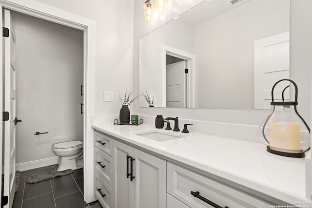 bathroom featuring toilet, vanity, and tile patterned flooring