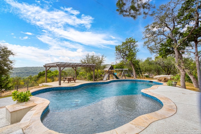 view of swimming pool featuring a patio area, a pergola, and a playground