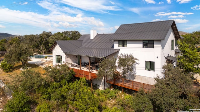 rear view of house featuring a swimming pool side deck