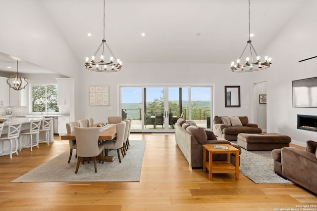 dining space with high vaulted ceiling, light hardwood / wood-style floors, and a healthy amount of sunlight