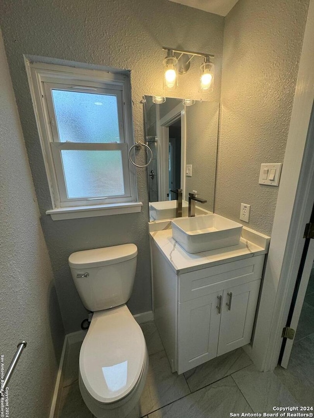 bathroom featuring tile patterned floors, vanity, and toilet