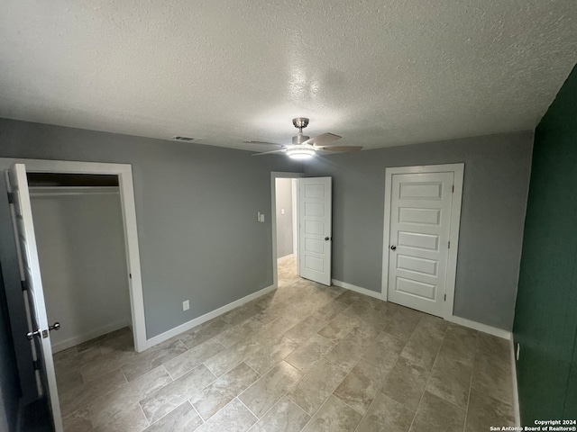 unfurnished bedroom featuring a textured ceiling and ceiling fan