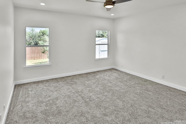 carpeted spare room with ceiling fan