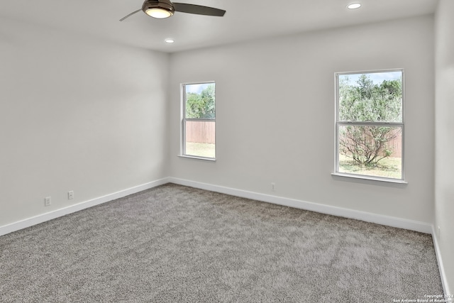 carpeted spare room with ceiling fan