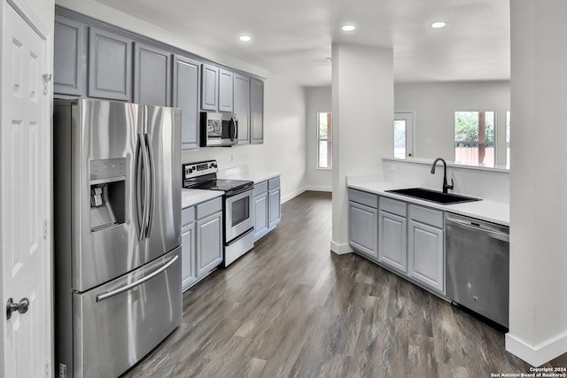 kitchen with gray cabinets, sink, dark hardwood / wood-style floors, and stainless steel appliances