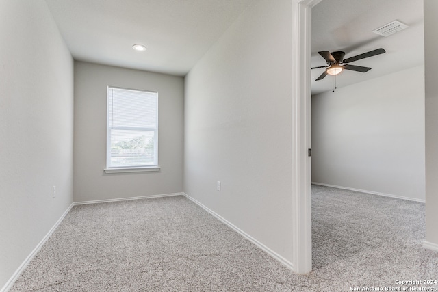 empty room featuring ceiling fan and light colored carpet