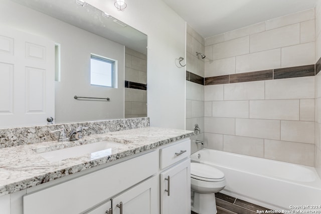 full bathroom featuring wood-type flooring, vanity, toilet, and tiled shower / bath